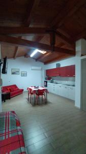 sala de estar con mesa y sofá rojo en Perdanoa - ApartHotel - F1469, en Ghilarza