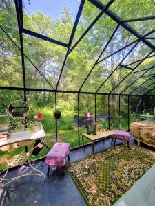 a room with a glass greenhouse with a table and chairs at Logements Insolites, Les Rêves d'Ambre 