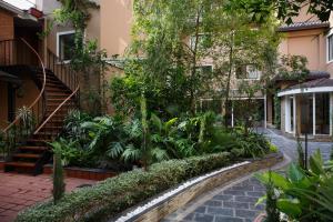 un jardin en face d'un immeuble avec un escalier dans l'établissement Hotel Thrive, A Tropical Courtyard, à Katmandou