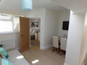 una sala de estar con una puerta que conduce a un dormitorio en 3TheDome - Luxury Ground Floor Apartment opposite the Beach, Barton on Sea, en Barton-on-Sea
