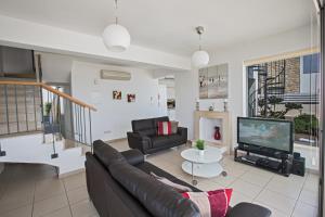ein Wohnzimmer mit einem Sofa und einem TV in der Unterkunft Esprit Villa 20 in Polis Chrysochous