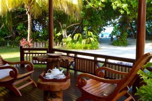 a table and chairs on a porch with a view of the beach at Les Villas D'or in Baie Sainte Anne