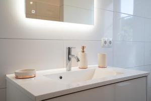 a white bathroom with a sink and a mirror at Reiterhof Behrens Ferienwohnung Hensen 