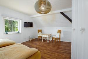 a bedroom with a bed and a table and chairs at Reiterhof Behrens Ferienwohnung Hensen 