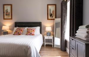1 dormitorio con 1 cama, 2 lámparas y espejo en The guest wing at kylemore house, 