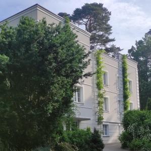 a white building with green ivy growing on it at Fryderyk in Krynica Morska