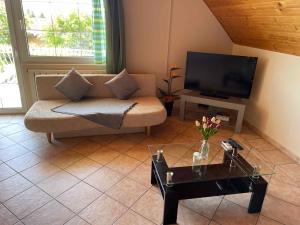 uma sala de estar com um sofá e uma televisão em Apartments in Gyenesdias/Balaton 39946 em Gyenesdiás