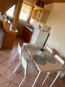 uma cozinha com uma mesa e cadeiras e um frigorífico em Apartments in Gyenesdias/Balaton 39946 em Gyenesdiás