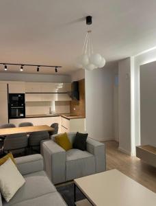 ein Wohnzimmer mit einem Sofa und einer Küche in der Unterkunft AirStay in Pristina