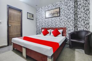 ein Hotelzimmer mit einem Bett und einem Stuhl in der Unterkunft OYO Flagship Hotel Skyorchid in Ābādpura