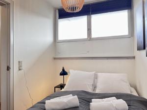a bedroom with a bed with white pillows and a window at One Bedroom Apartment In Valby, Langagervej 64, 3 in Copenhagen