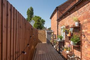 a brick fence with a brick walkway with potted plants at The Hideaway 