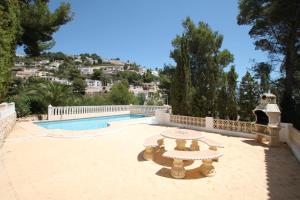 モライラにあるFrajapie - sea view villa with private pool in Morairaのスイミングプールの隣にテーブル付きのパティオ