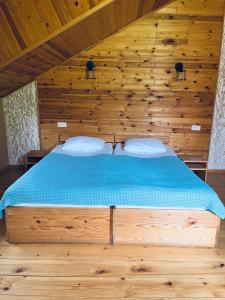 1 dormitorio con 1 cama en una habitación de madera en Ioska's House en Mestia