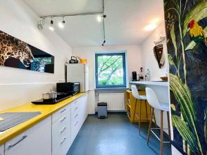 a kitchen with white cabinets and a yellow counter top at Ferienbungalow Iwele Marktbreit in Marktbreit