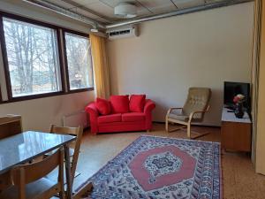 a living room with a red couch and a table at Sippolantie 11 in Kouvola