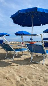 two chairs and an umbrella on the beach at Maronda Camping in Marina di Montenero