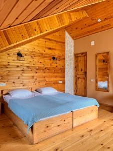 a bedroom with a bed in a wooden room at Ioska's House in Mestia