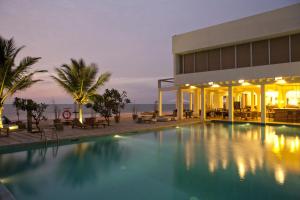 a hotel with a swimming pool in front of a building at Jetwing Sea in Negombo