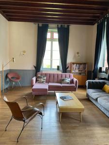 a living room with a pink couch and a coffee table at Le Jardin du Clocheton, jardin et parkings privés, centre Etretat in Étretat