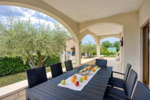 a table with fruit on it on a patio at Holiday House Iris with Private Pool in Poreč