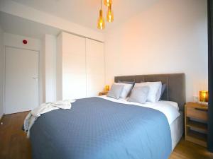 a bedroom with a large blue bed with white pillows at Rogowo 117J Shellter Apartments in Rogowo
