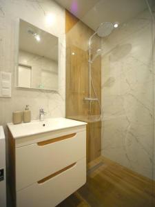 a white bathroom with a sink and a shower at Rogowo 117J Shellter Apartments in Rogowo
