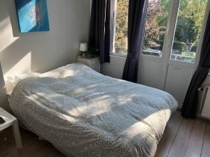 ein Schlafzimmer mit einem Bett, auf dem eine Decke liegt in der Unterkunft Studio confort Verviers in Verviers