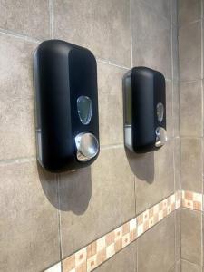 two black paper towel dispensers on a bathroom wall at Fish Lodge in Paea