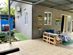 un patio con una cama y una pared con carteles en Fish Lodge, en Paea