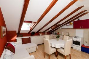 eine Küche und ein Wohnzimmer mit einem weißen Tisch und Stühlen in der Unterkunft Apartment Mala Ana in Dubrovnik