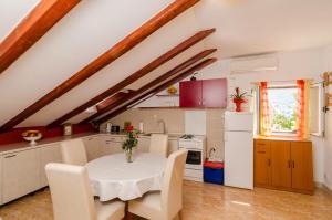 eine Küche mit einem weißen Tisch und Stühlen in einem Zimmer in der Unterkunft Apartment Mala Ana in Dubrovnik