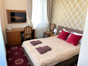 een slaapkamer met een bed met rode kussens erop bij Hotel President in Kock