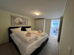 una camera da letto con un grande letto con lenzuola bianche di Up de Kek im Friesenhaus Sieben Linden ad Archsum