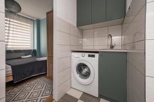 eine Küche mit einer Waschmaschine in einem Zimmer in der Unterkunft MW Apartamenty - Gdynia Witomino blisko centrum in Gdynia