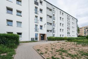 Blick auf ein weißes Gebäude mit Innenhof in der Unterkunft MW Apartamenty - Gdynia Witomino blisko centrum in Gdynia