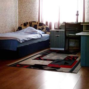 a bedroom with a bed and a rug on the floor at Zajazd Private in Suwałki
