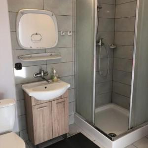 a small bathroom with a sink and a shower at Zajazd Private in Suwałki