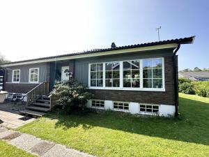 a house with a large window on the side of it at Unique villa with spa and sauna in Tanumshede in Tanumshede