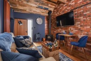 a living room with a couch and a brick wall at The Hideaway 