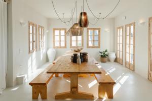 una mesa de madera en una habitación con ventanas en Scorpios Beach, en Monolithos