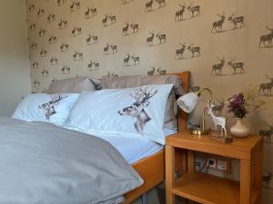 1 dormitorio con 1 cama con un mural de ciervos en la pared en Haus Seebach en Mallnitz