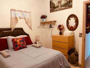a bedroom with a bed with a dresser and a mirror at Cozy Apartment Villas in Rosarito