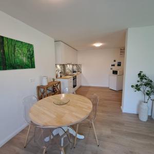 a dining room with a table and chairs and a kitchen at Ferienwohnung Muota in Muotathal