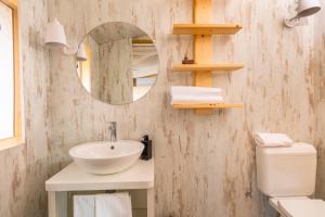 a bathroom with a sink and a mirror and a toilet at Le Lenze Don Mimì Glamping in Mattinata