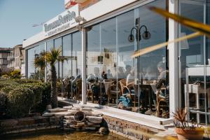 a group of people sitting at tables in a restaurant at Hotel Villa Sorriso in Lido di Jesolo +106 photos