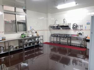 eine große Küche mit Küchengeräten aus Edelstahl in der Unterkunft Chia Yuen Homestay in Fenchihu