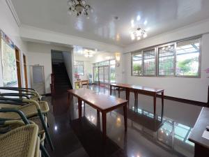Zimmer mit 2 Tischen, Stühlen und Fenstern in der Unterkunft Chia Yuen Homestay in Fenchihu