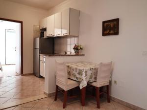 La cuisine est équipée d'une table, de chaises et d'un réfrigérateur. dans l'établissement Seaview, à Vrboska