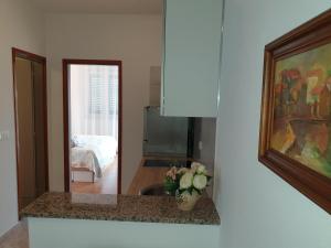 a kitchen with a counter with a vase of flowers at Seaview in Vrboska +6 photos